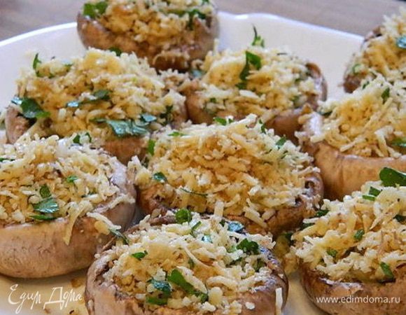 Готовим начинку: орехи измельчить, сыр потереть на мелкой терке, петрушку мелко порубить, чеснок пропустить через пресс, посолить и поперчить. Перемешать. Наполнить шляпки начинкой.