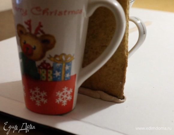 Приступаем к сборке и оформлению.
Переложить сахарную глазурь в кондитерский мешок и склеить все части согласно своему эскизу. Чтобы стенкам было проще держать нужную форму, используйте чашки для опоры.