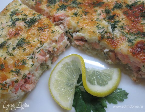 Сначала приготовим лук: нарежем кольцами и обжарим на 1/2 части сливочного масла.   
Теперь в круглую форму, смазанную маслом, кладем слоеное тесто, обрезаем лишнее. Вилкой делаем несколько проколов. 
По поверхности теста распределяем весь обжаренный лук и остатки сливочного масла. Сверху выкладываем кусочки филе лосося.
Теперь соус: соединяем яйцо, сыр, разбавляем молоком, добавляем соль, перец по вкусу.