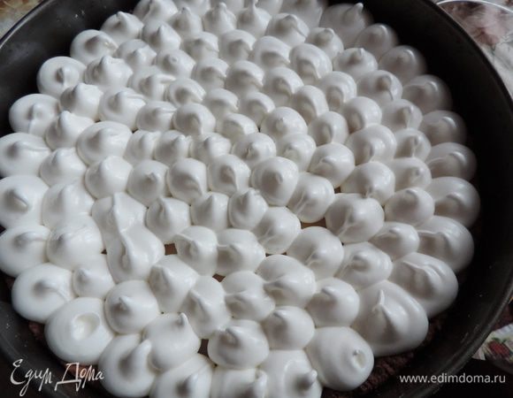 Переложить белковую массу в кондитерский мешок с круглой насадкой и отсадить пики сверху на творожный слой. Если лень возиться с мешком и насадкой, можно просто распределить безе сверху по пирогу и ложкой сделать «волны».