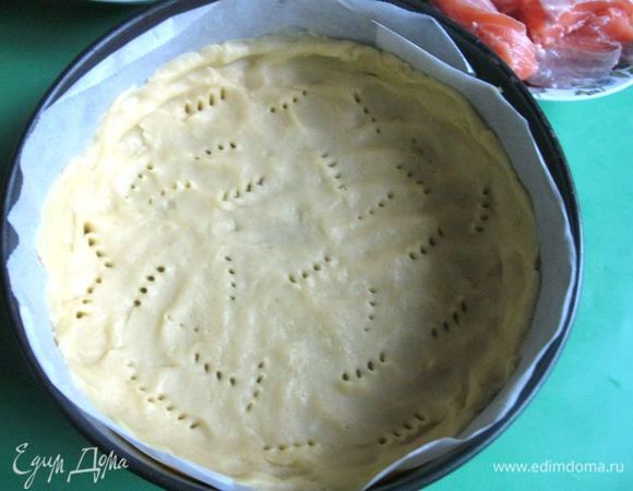 Приготовить тесто. В муку добавить соль, перемешать, поместить на рабочую поверхность, добавить охлажденное сливочное масло, порезанное кусочками. Порубить ножом в крошку. Скатать шар, завернуть в пленку, убрать в холодильник на 30-40 минут.
Достать тесто, нижнюю часть формы закрыть пекарской бумагой, выложить на нее тесто, оставив часть на бортики, разровнять, присоединить боковую часть формы, закрыть ее пекарской бумагой, добавить оставшуюся часть теста по бортику. Проколоть на нижней части теста дырки вилкой. 

