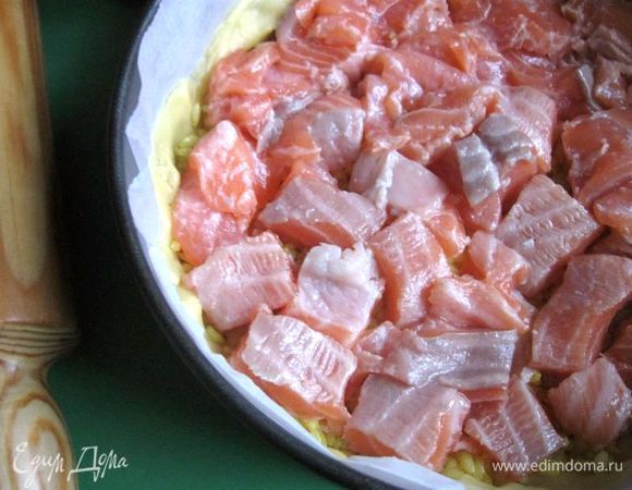 Затем положить равномерно по поверхности кусочки филе лосося. 