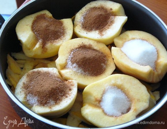 Теперь достаем айву из воды и выкладываем ее на сковороду, сердцевиной кверху. В центр каждой половинки засыпаем полстакана сахара и пол чайной ложки корицы. Бросаем гвоздику.