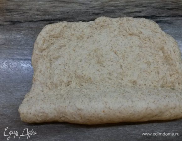Готовое тесто еще раз обминаем и оставляем на столе на 10 минут отдохнуть. 
После этого начинаем формовку. Можно сформировать батон. Для этого из теста формируем прямоугольник, толщиной 1.5-2 см. Вдоль короткой стороны начинаем тесто заворачивать рулетом, после каждого оборота тщательно защипывая.