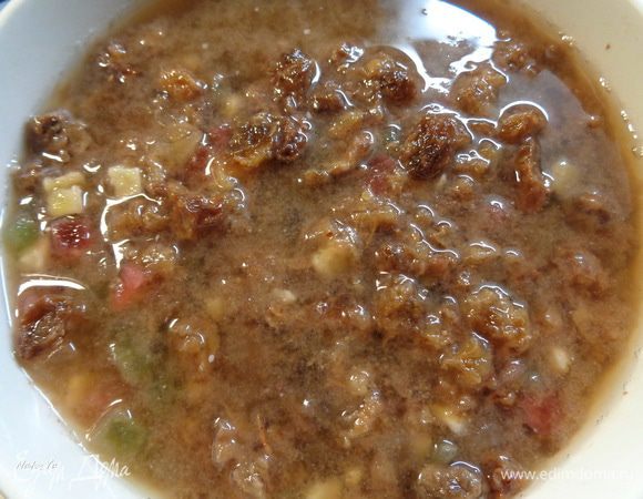 Изюм и цукаты залить горячей водой, добавить ром, перемешать и оставить на 30 минут.