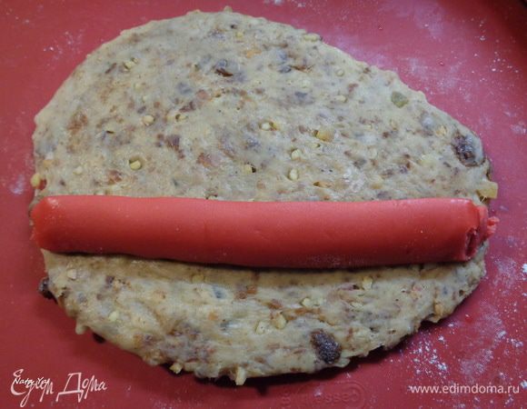 Полоску марципана положить у края раскатанного теста, отступив немного от края.