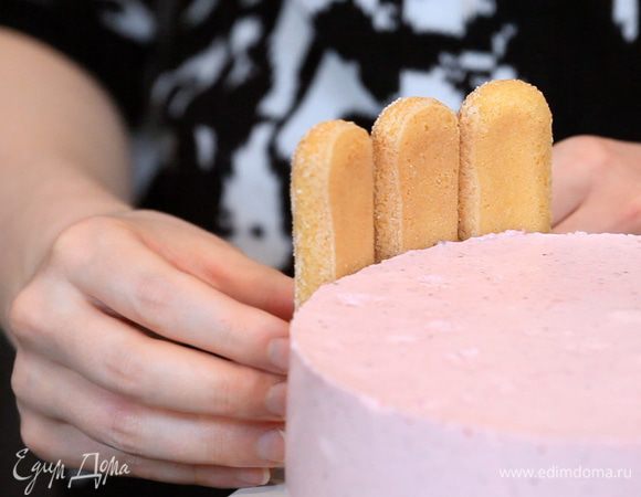 Аккуратно убираем пленку и оформляем бока торта печеньем савоярди.