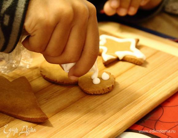 Отправить в разогретую духовку на 7-12 минут, как только начинает румяниться — можно вынимать, иначе легко пересушить.
Пока они остывают, миксером взбить один белок с сахарной пудрой и лимонным соком. Взбивать не менее 5 минут, лучше 7. Глазурь получается гладкая, слегка тягучая. Мне удобнее всего ею украшать, используя небольшие пакетики, отрезав уголочек. Мои помощники тоже легко справились с таким инструментом!