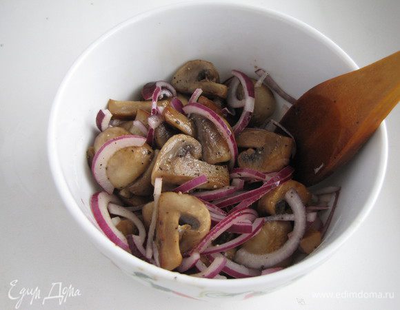 Готовые шампиньоны выложить в миску, посолить, поперчить, добавить мелко нарезанный зубчик чеснока и красный лук, нарезанный тонкими полукольцами. Добавить несколько капель уксусной эссенции. Все хорошо перемешать и оставить остывать. 