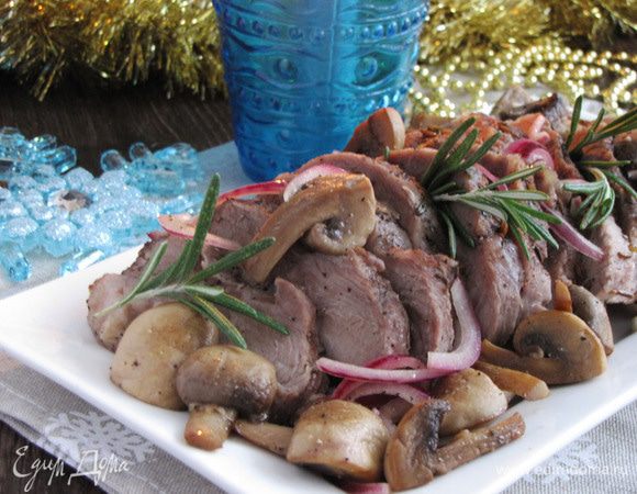 Убрать траву и лавровый лист, нарезать мясо на кусочки. Выложить на блюдо, сверху распределить шампиньоны с луком. Сразу же подавать на стол. Приятного аппетита и счастливого Нового года!