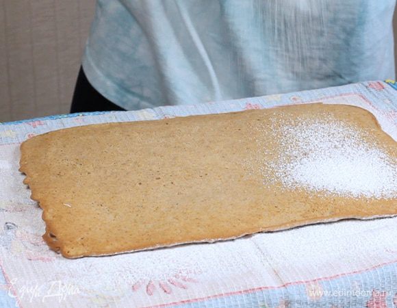 Положите сверху бисквит, ещё раз посыпьте пудрой.