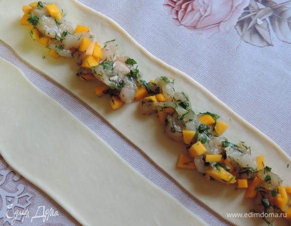 Теперь можно приступить к формированию "розочек". Берем кусочек теста размером чуть больше грецкого ореха. Раскатываем его в прямоугольник примерно 5x20 см. По средине по всей длине прямоугольника, не доходя до краев, выкладываем начинку. Ее должно быть столько, чтоб вы могли свободно слепить края полоски.