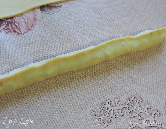 Защипываем вдоль большей стороны. Получаем длинную и тонкую "колбаску". Можете ее слегка примять, чтоб начинка в середине распределилась более равномерно.