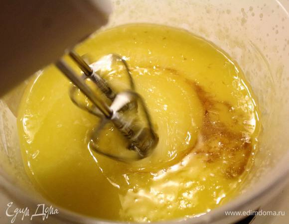 Включить духовку на 180°C. Тесто готовится быстро, поэтому к окончанию замеса, как раз будет готова и духовка. Растопленное сливочное масло смешать с сахаром до однородности, добавить в него ванильную эссенцию. По одному добавить яйца, каждый раз хорошо размешивая смесь.