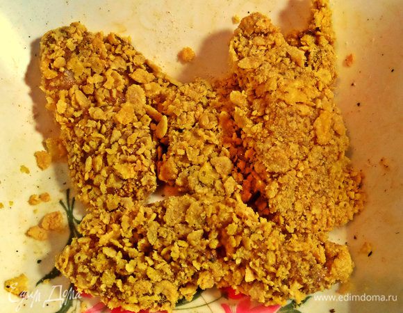 Настала очередь основной наружной панировки. Окунаем в кукурузную крошку каждый кусочек, прижимаем.