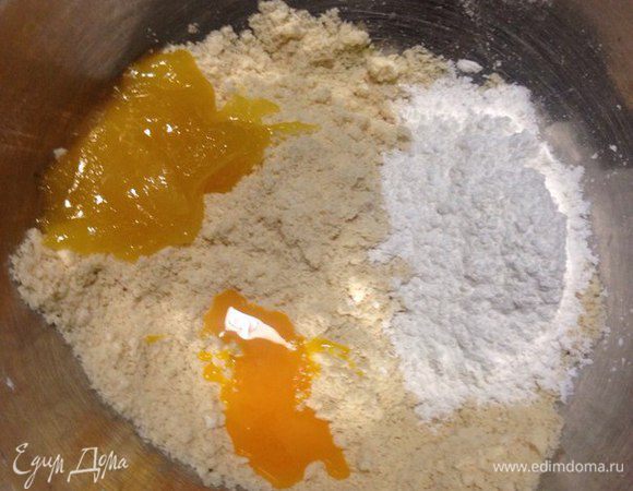 Теперь в получившееся тесто засыпаем сахарную пудру, мед и желток, все перемешиваем, тесто получается очень крутое и гладкое, если слишком жидкое тесто, то добавьте муки, а если рассыпается, то немного меда.
Но сначала хорошо вымесите тесто.