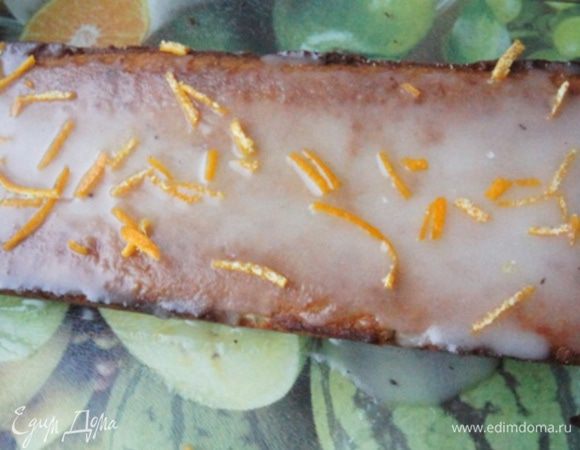 Приготовить глазурь: сахарную пудру насыпать в миску и добавить пару ложек горячей воды. Смешать, нанести на остывший кекс и украсить цедрой апельсина!