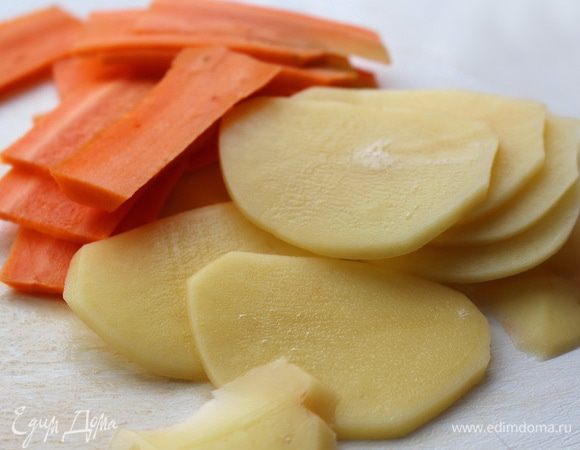 Сделать чипсы. Картофель и морковь почистить и натереть на терке-мандолине.