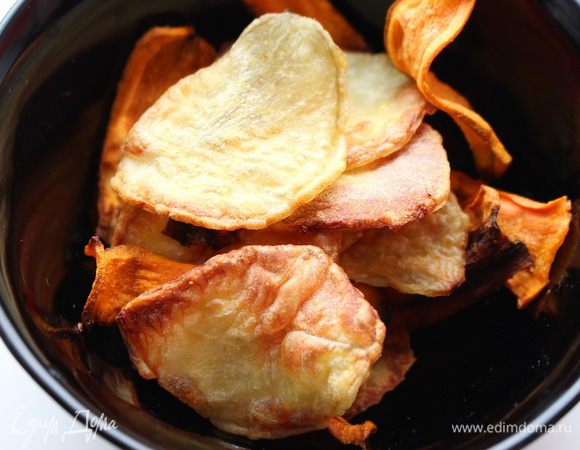 Сбрызнуть растительным маслом, присыпать солью и сушеным чесноком, тщательно перемешать. Готовить в предварительно разогретой до 120°C духовке 40-60 минут. Часть чипсов измельчить в крошку.