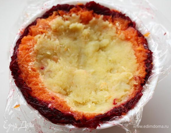 2 небольшие миски в форме полусферы застелить пищевой пленкой. В каждую миску выложить слоями свеклу, морковь, картофель, лук, сельдь и натертый белок. Между слоями промазывать майонезом и бальзамическим кремом.