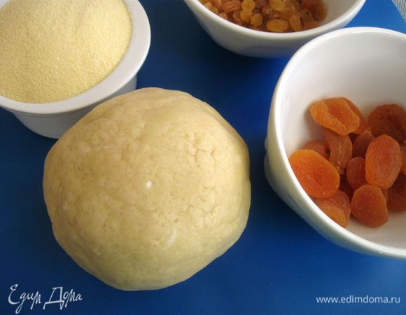 Смешать сухие компоненты: муку, крахмал, сахар, соль. Добавить размягченное сливочное масло, яйцо. Скатать шар, завернуть в пленку, убрать в холодильник на 1 час.
Замочить в кипятке курагу, изюм, откинуть на сито, дать просохнуть. Курагу мелко порезать.
