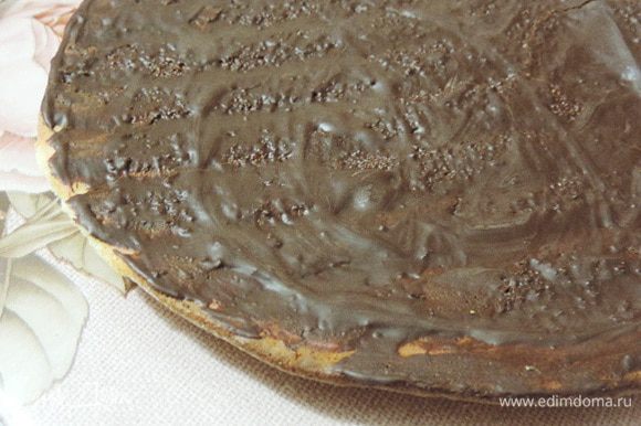 Нам понадобится дополнительно грамм 20-25 черного шоколада. Его нужно растопить и смазать им один из бисквитных пластов. Даем шоколаду затвердеть, для ускорения процесса поместите этот пласт бисквита в холодильник.