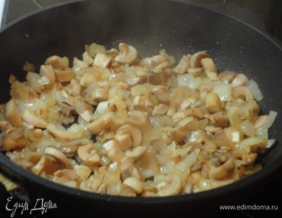 Лук нарезать мелкими кубиками и обжарить до золотистого цвета на 2 ложках растительного масла. Добавить грибы и жарить, пока не испарится жидкость.