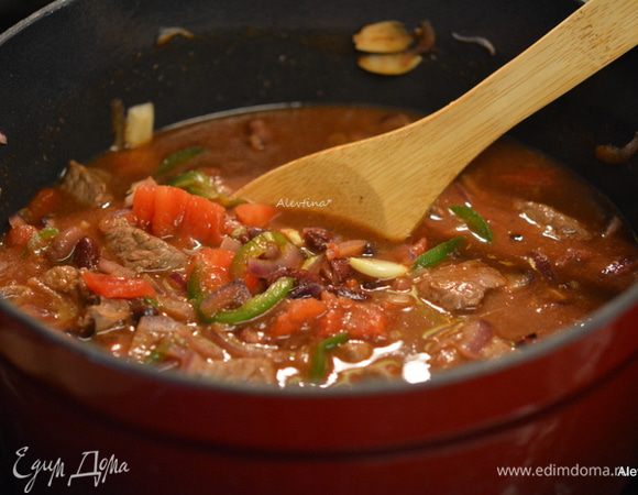 Добавить 1-2 стакана воды, так чтобы овощи и говядина были полностью покрыты, перемешать, закрыть крышкой и тушить 1,5-2 часа.
