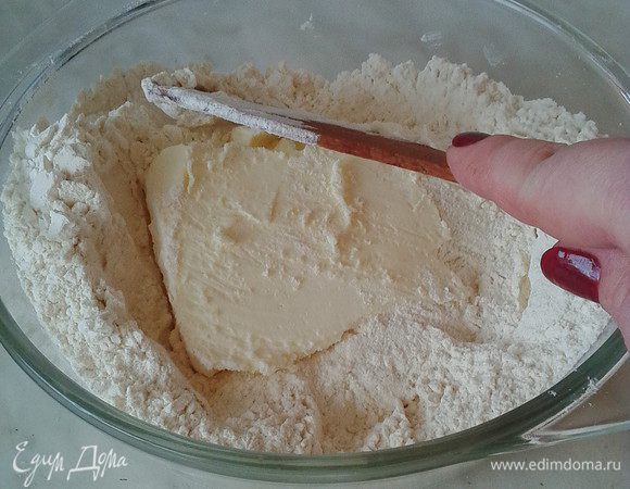Приступаем к песочным коржам. Для этого в миске смешиваем до состояния крошки просеянную муку с холодным маслом (у меня растительно- сливочная смесь), добавляем разрыхлитель.