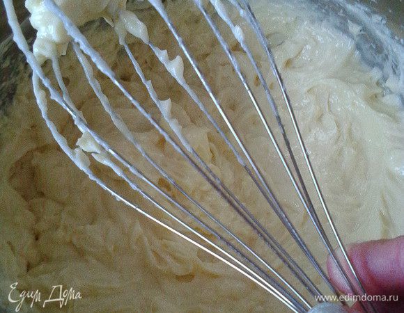 Пока коржи остывают, приготовим крем: 600 г молока в сотейнике поставим нагреваться, оставшиеся желтки и  200 г холодного молока смешаем с мукой, крахмалом и ванилью и, смешав до однородности, вводим в нагретое молоко. Проварить 1-2 минуты, хорошо остудить. Взбить мягкое масло с сахарной пудрой, добавляем к нему заварную молочную смесь частями, взбивая всё вместе пару минут. Крем должен получиться воздушным, пышным, плотным. Отложим несколько ложек крема и добавим какао 1-2 чайных ложки для декора верха торта.