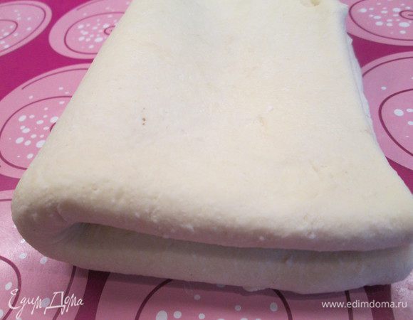 Через 12 часов раскатываем тесто в пласт 40х50 и складываем сначала втрое, свернув один край до середины, а сверху накрыв вторым — раскатываем и затем снова складываем, только теперь вчетверо.