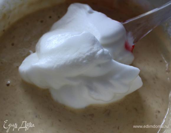 Аккуратно лопаткой заворачивающими движениями вмешать одну треть белков в тесто. Затем вмешать еще треть и затем вмешать оставшуюся. Таким образом легче сохранить воздушность взбитых белков.