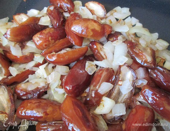 Пока маринуется курочка, готовим для нее начинку: из фиников вынимаем косточки и разрезаем пополам. Виноград тоже режем на две части и, если есть в нем косточки, удаляем. Обжариваем отложенную часть лука и чеснока, добавляем к ним финики. Тушим 5 минут в бульоне.