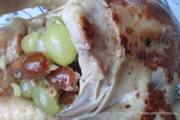 Маринад, в котором была курица добавляем к тушеным финикам с луком и немного прогреваем. Курицу укладываем на блюдо, наполняем начинкой, смешивая ее с виноградом. Закрепляем тушку курицы шпажками.