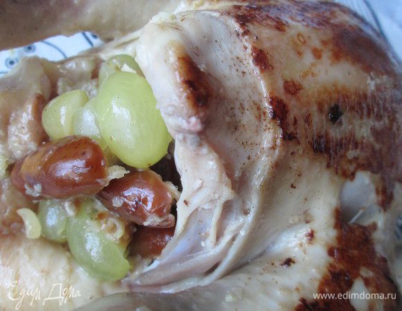 Маринад, в котором была курица добавляем к тушеным финикам с луком и немного прогреваем. Курицу укладываем на блюдо, наполняем начинкой, смешивая ее с виноградом. Закрепляем тушку курицы шпажками.