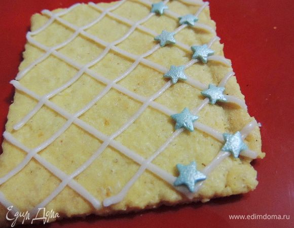 Крышу домика я решила украсить звездочками. Густым айсингом наносим решетку, сразу же крепим сахарные украшения.