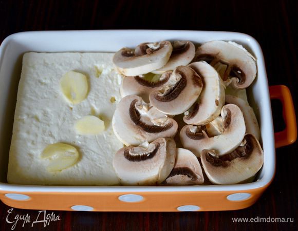 В формочку (лучше керамическую) кладем сыр Фета. За неимением можно заменить на не очень соленую брынзу. На сыр выложить чеснок, лук и грибы. 
