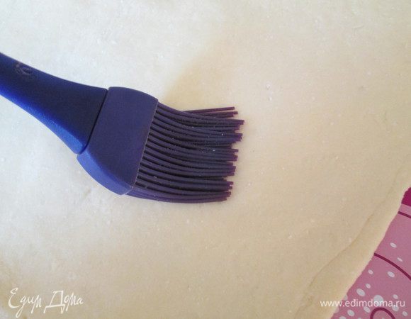 Теперь раскатываем толщиной чуть меньше 1 см. У меня около 0,7-0,8 см. Можно делать толще как у Карла — 1,5 см. Разрезаем заготовки на две части для двух штруделей. Смачиваем одну часть (половину каждой заготовки) водой.