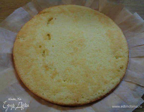 Первый корж выкладываем на блюдо. Я по краям проложила нарезанную на кусочки пекарскую бумагу, чтобы не испачкать блюдо при украшении.