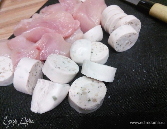 Куриное филе вымыть и разрезать на довольно крупные кусочки, так же порезать колбаски. 