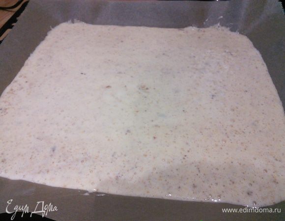 Противень выслать пекарской бумагой и распределить бисквитное тесто, разровнять и выпекать в заранее разогретой до 200°С духовке 8 минут. 