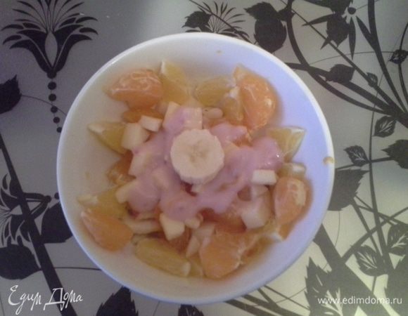 Сверху салата положить кружок банана, по бокам расставить апельсинки и мандаринки. Салат фруктовый готов!