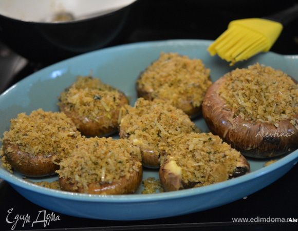Заполнить шляпки грибов смесью. Сбрызнуть остатками масла. Поставить в горячую духовку на 25 минут.