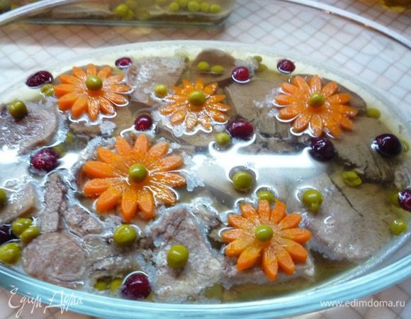 Украшаем заливное ягодами клюквы, зеленым горошком, по необходимости доливаем бульон и убираем на ночь в холодильник.