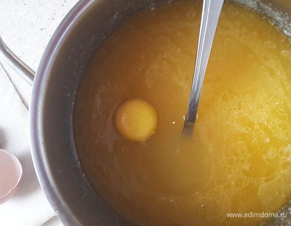 Затем положить сливочное масло. Растворить в теплой смеси и вбить яйцо. Размешать до растворения сахара и нагреть почти до кипения. Снять с огня.