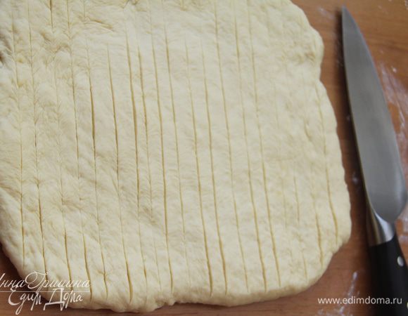 На другой день достать тесто из холодильника, дать ему согреться (примерно 1 час). Я помогала тесту согреться, слегка вымешивая его. Рабочую поверхность слегка присыпать мукой. Раскатать тесто в пласт толщиной 2,5 см. Ножом на поверхности сделать неглубокие надрезы-насечки на расстоянии примерно через 1 см.