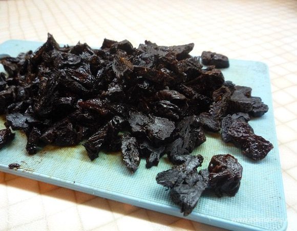 Чернослив заливаем теплой водой на несколько минут, сливаем воду, просушиваем и нарезаем небольшими кусочками.