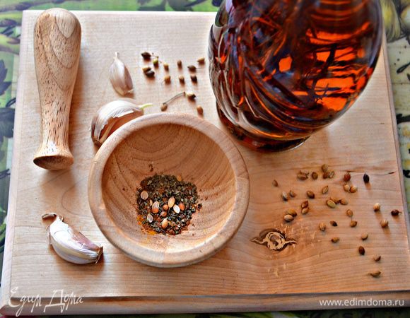 Чеснок очистите и разрежьте каждый зубчик вдоль на 3-4 ломтика. Специи соедините в ступке и разотрите. Переложите в небольшую ёмкость, добавьте оливковое масло и перемешайте.