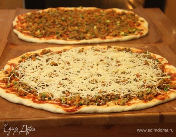 Сверху посыпать тёртым пармезаном. 
Выложить пиццу на горячий противень и выпекать при 250°С, 5-6 минут.