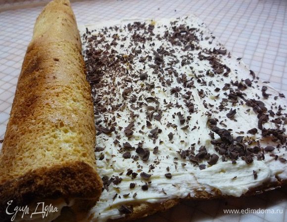 Остывший рулет разворачиваем, смазываем кремом и поверх крема посыпаем натертым на крупной терке горьким шоколадом. Часть крема оставляем для украшения.